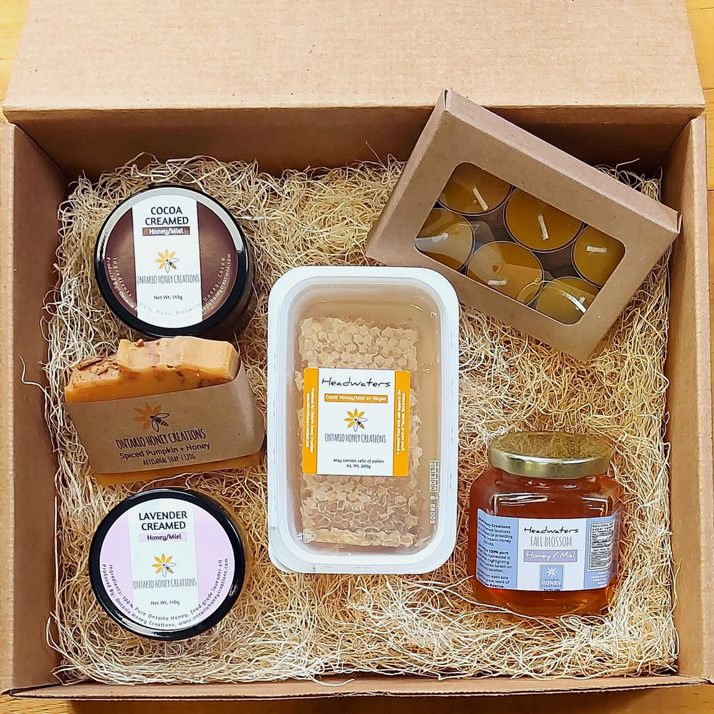 Gift box with Honey Comb, Cocoa and Lavender Creamed Honey, Beeswax Tealight Candles, and Headwaters Fall Blossom Honey.