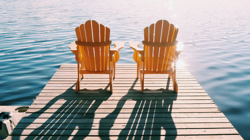 Two chairs on a dock overlooking the lake