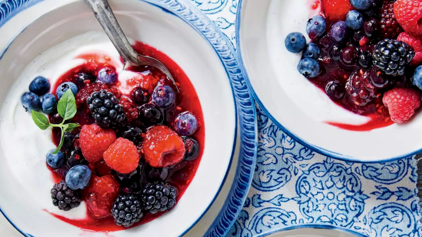 Warmed berries with honey and cheese in bowl